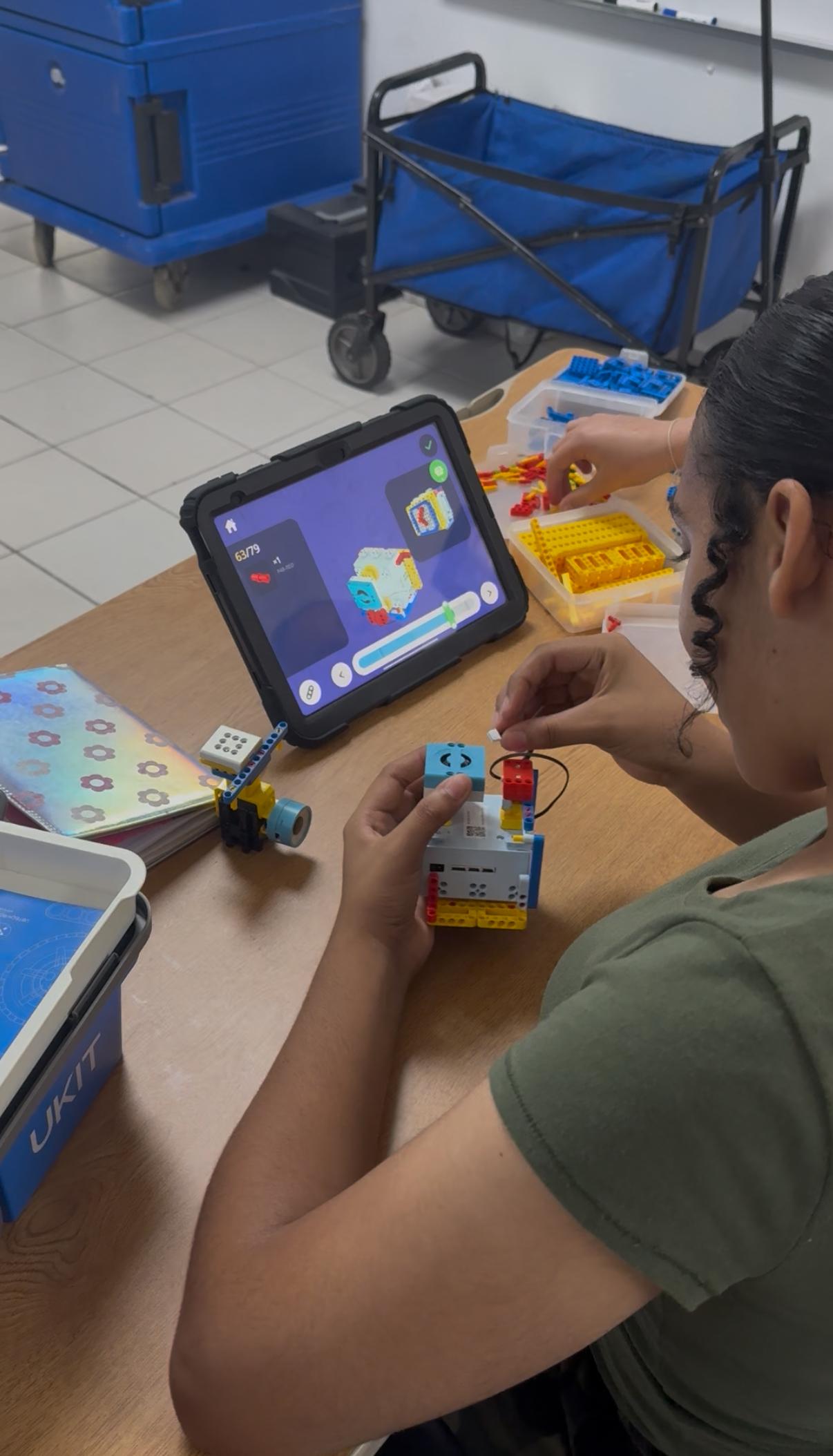 Niños construyendo robots en equipo durante curso de robótica en Puerto Rico