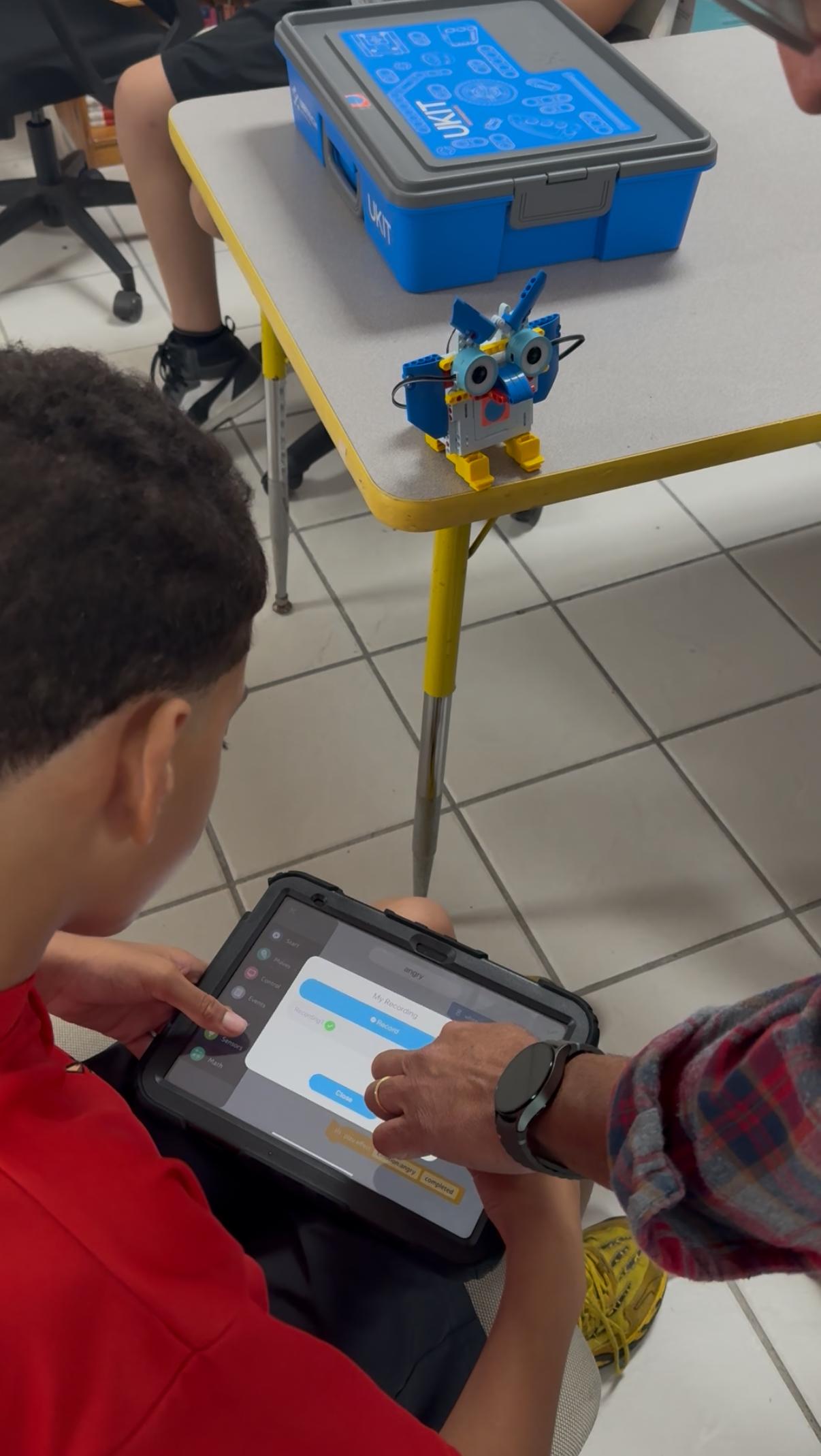 Niños trabajando con robots y sensores en MiniGeeks